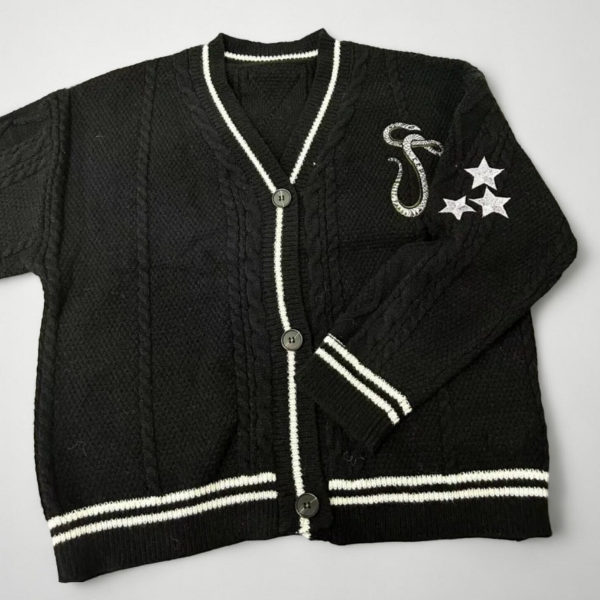 black reputation cardigan with white stars on left hem and embroidered snake